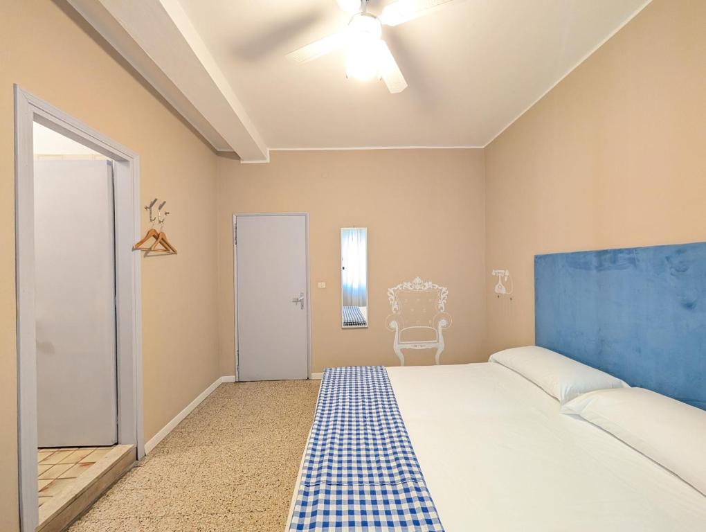 a bedroom with a large bed and a blue headboard at Locanda San Marco in Caorle