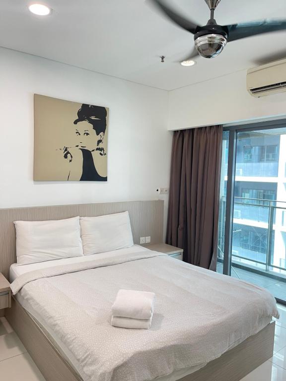 a bedroom with a large white bed with a window at Mercu Summer Suites Apartment With Balcony in Kuala Lumpur