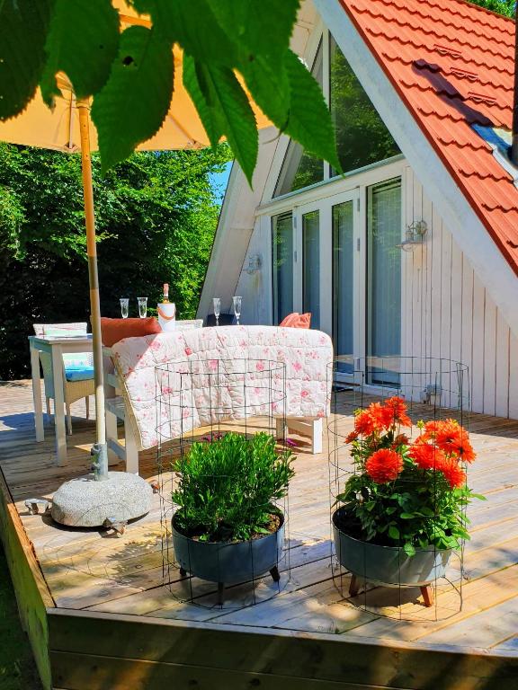a patio with two pots of flowers and a couch at The Doll House - Adults Only in Ebeltoft