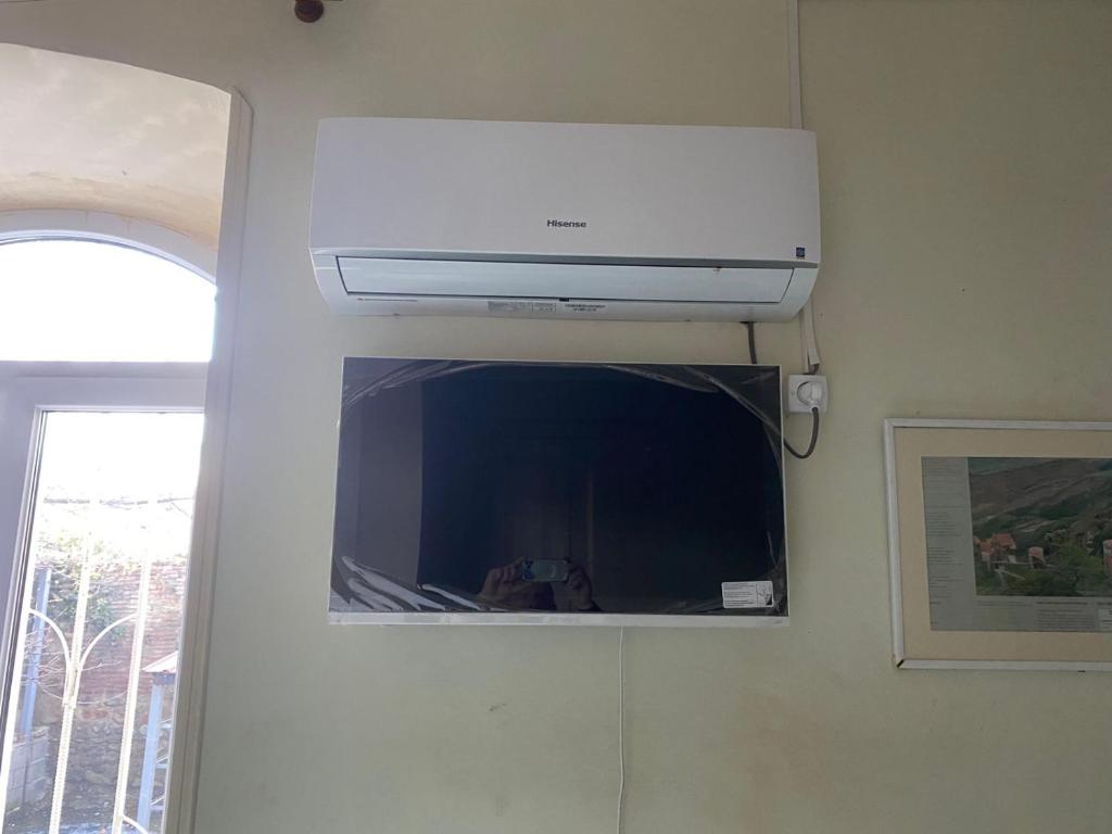 a television hanging on a wall in a room at Vino Vista in Tʼelavi
