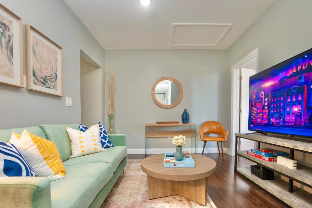 a living room with a green couch and a tv at Spacious 3BR Near NYC with Workspace in Newark