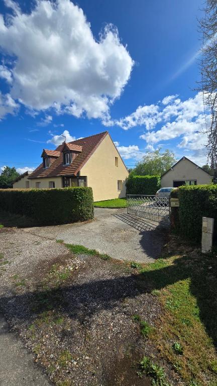 une maison jaune avec une clôture devant elle dans l'établissement Chambres de charme en Normandie, à Hauterive