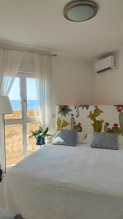a bedroom with a white bed and a window at Torre dei Pirati in Letojanni