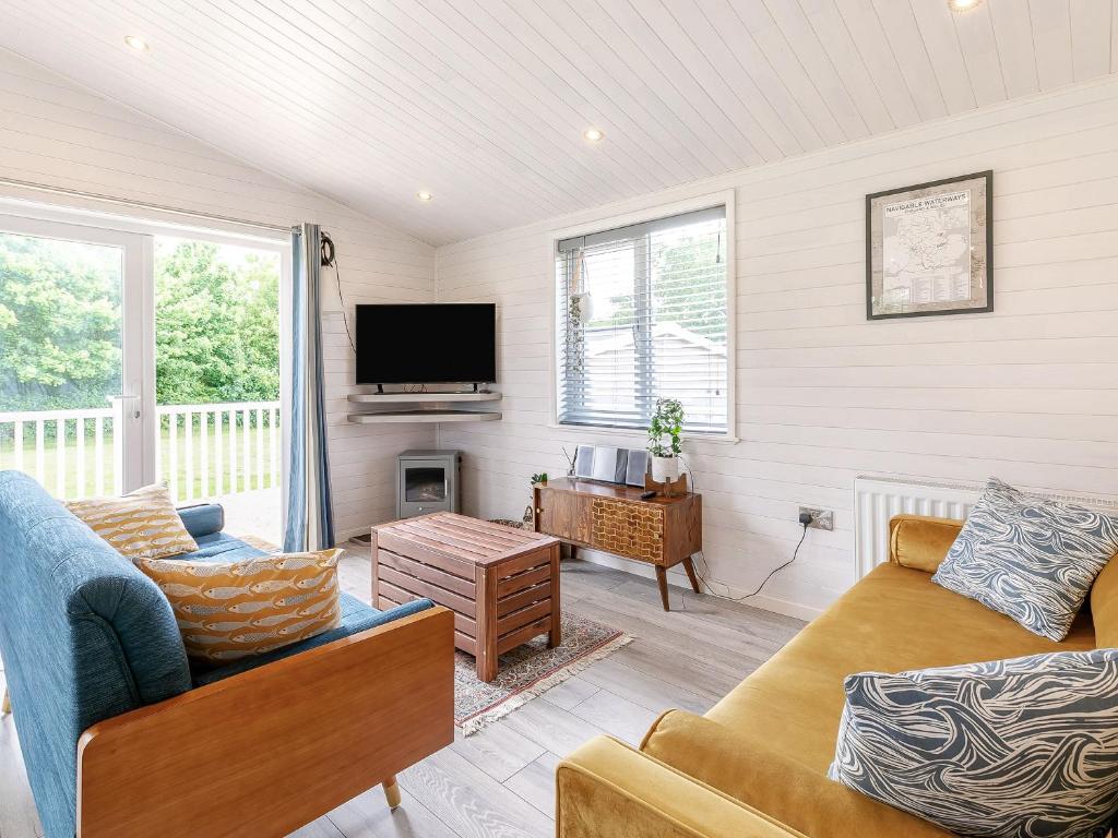 a living room with a couch and a tv at Erica Lodge in Willington