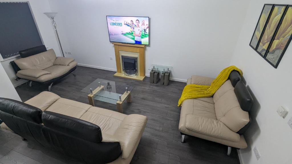 a living room with two couches and a television at Leyland Road Retreat - 4 Bedroom House in Burnley