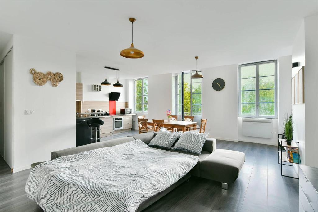 Un dormitorio con una cama y una sala de estar. en Spacieux Centre-ville Balcon, en Saint-Étienne