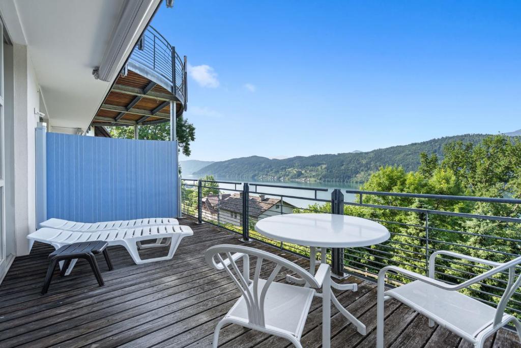 a balcony with a table and chairs and a view of the water at Auszeit Seeblick Panorama in Millstatt