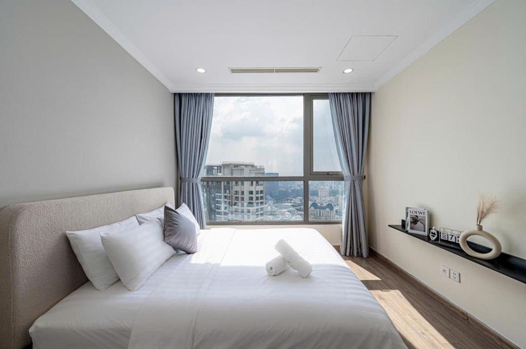 a bedroom with a bed with a teddy bear on it at Origami Vinhomes Grand Park Q9 in Gò Công