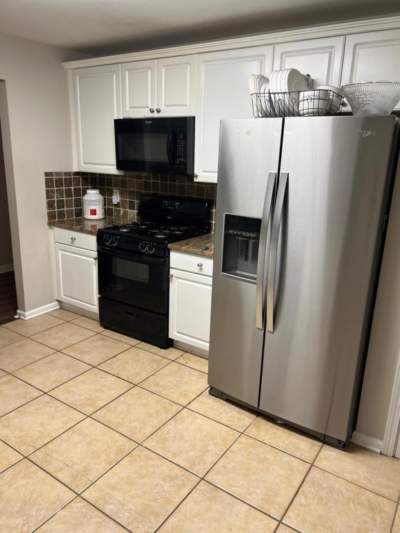 a kitchen with a stainless steel refrigerator and a stove at The Plush Retreat Marietta With Soaker Tub Walk In Closet in Marietta