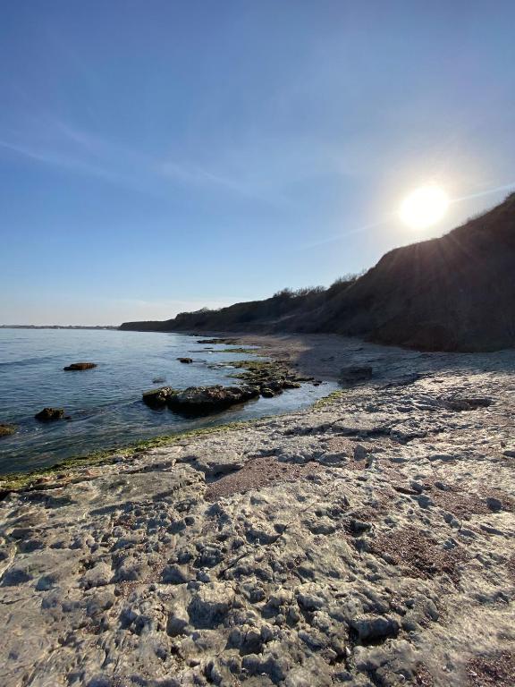 a rocky beach with the sun rising over the ocean at Sea Side in Vama Veche