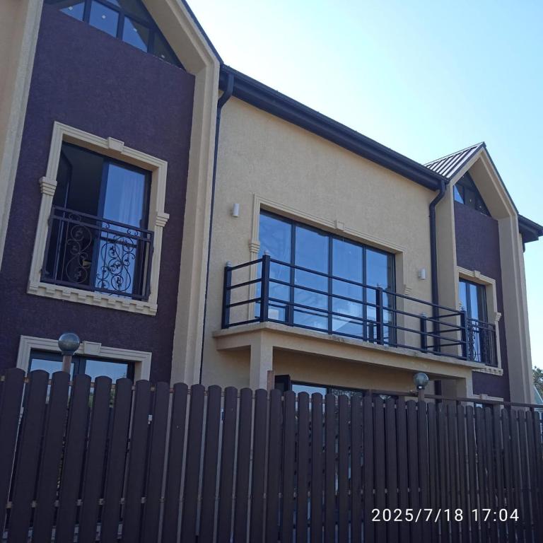 a house with a black fence in front of it at Hotel Nia in Ureki