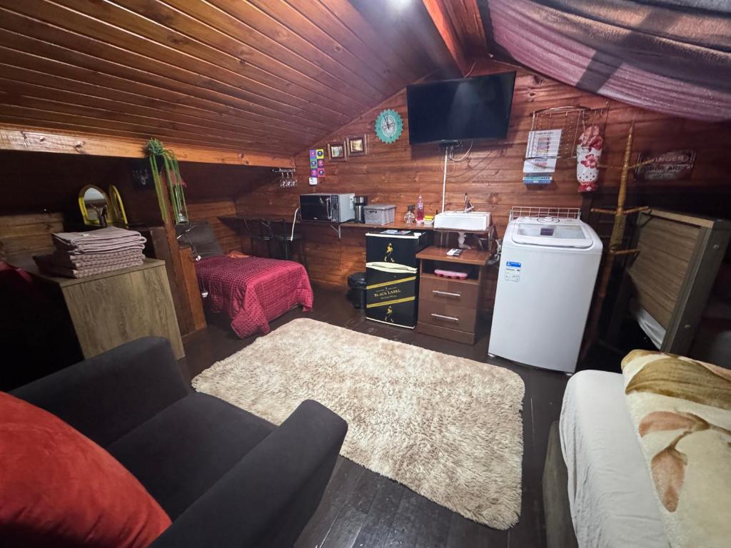 a living room with a couch and a tv in a room at Ático com Ar Condicionado Q e F in Ponta Grossa