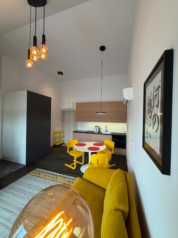 een woonkamer met een gele bank en een tafel bij Sunny Jantar in Jantar