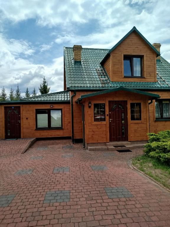 a house with a brick driveway in front of it at Przytulny kąt in Białowieża