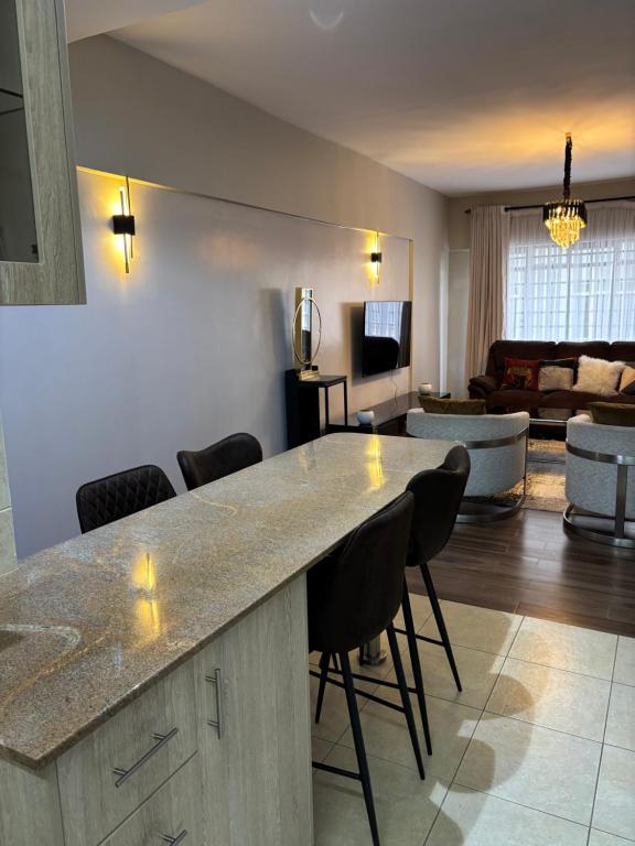 a kitchen and living room with a counter and chairs at Davinia Haven in Nairobi