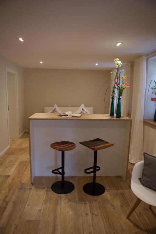 a kitchen with a counter and two stools at Landers Ferienwohnung in Sankt Martin