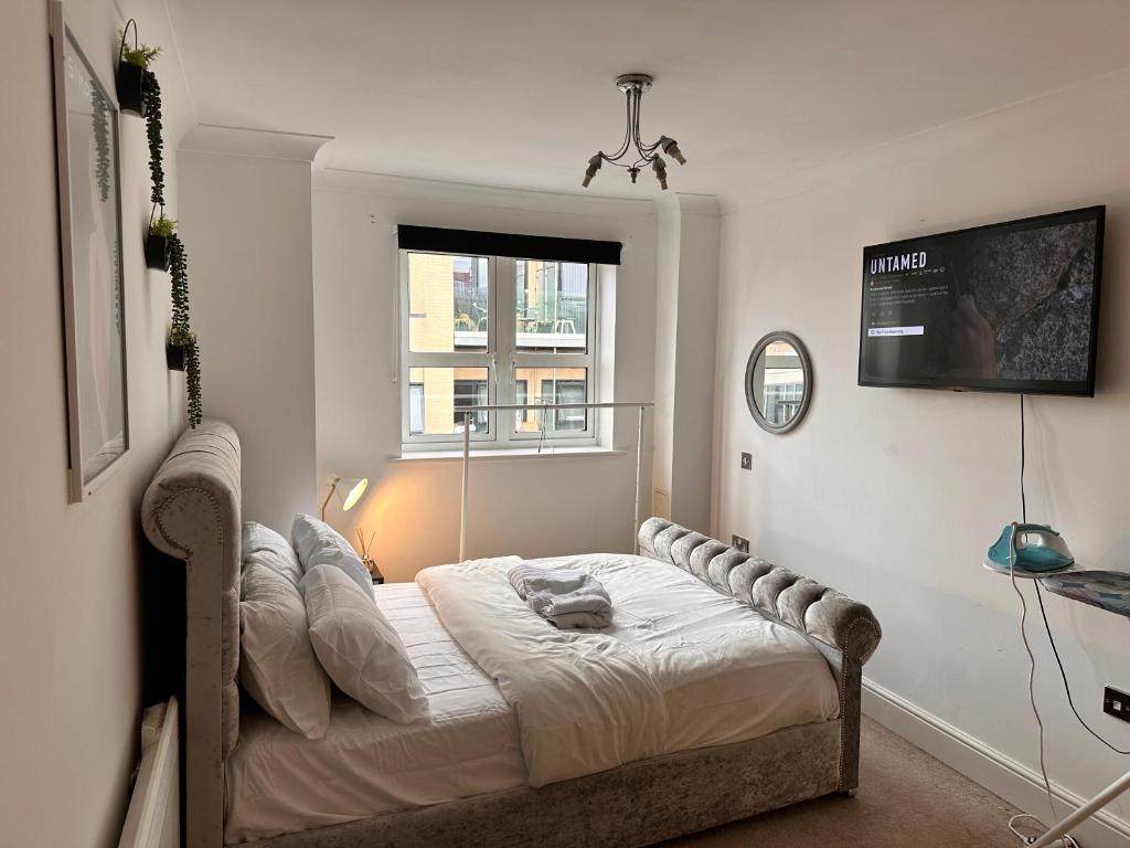 een slaapkamer met een bed in een kamer met een raam bij Enjoy city living in this one-bedroom flat, complete with a balcony and secure parking in Birmingham city center in Birmingham