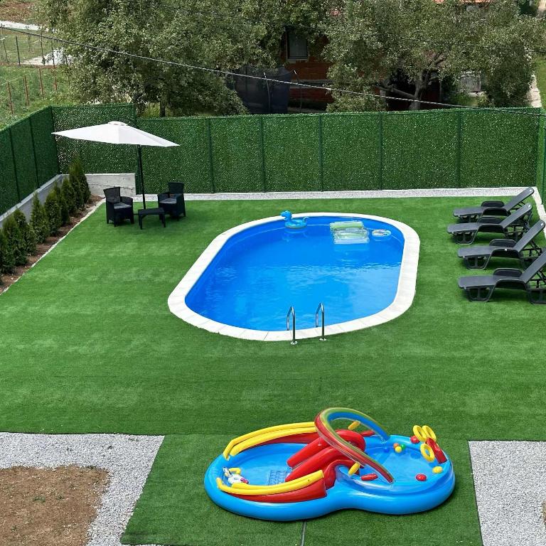 a swimming pool with a inflatable toy in the grass at Holiday home Mumi in SJJ