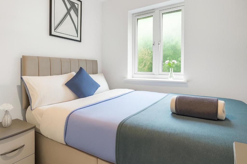 Ince-in-Makerfieldにある4-Bed House for Contractors, Groups, Families, WiFi, Parking, SmartTV, Sleeps 10, Near Wigan Pierのベッドと窓のある寝室