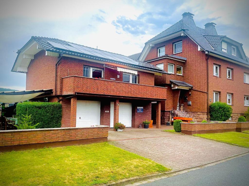a large red brick house with white garage at Ferienhaus Ahlborn in Uslar