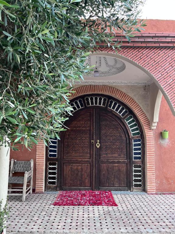 a large wooden door with red flowers in front of it at Charming villa in Safi in Safi
