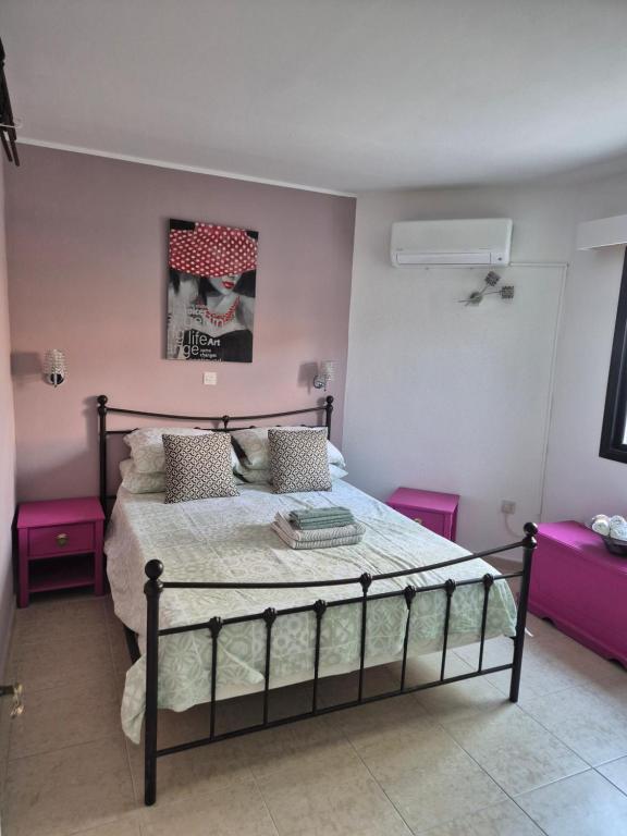 1 dormitorio con 1 cama con paredes de color rosa en Sea Nest, en Pafos