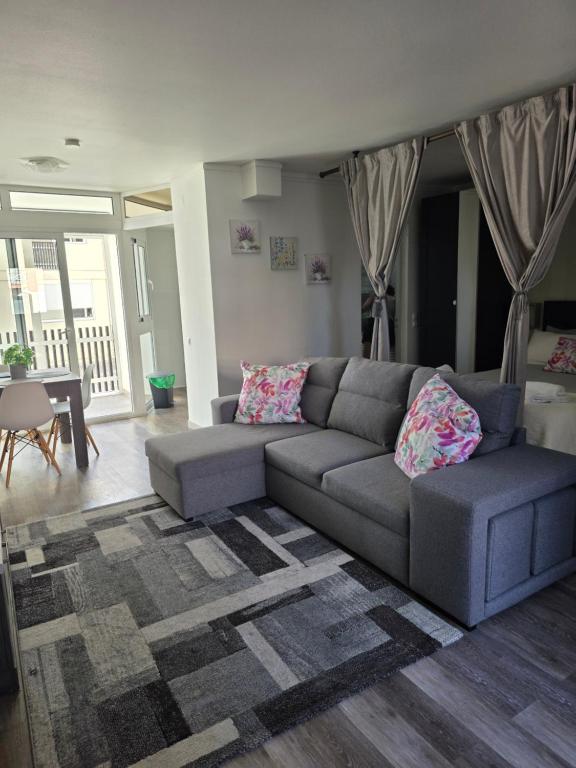 a living room with a gray couch and a table at Marina Biarrits in Vilamoura