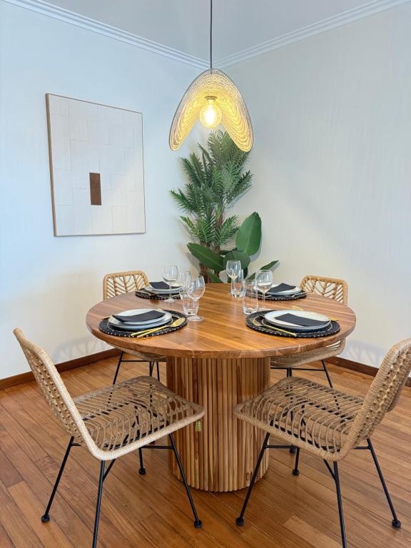 Porta14 Praia في بوفوا دي فارزيم: غرفة طعام مع طاولة وكراسي خشبية