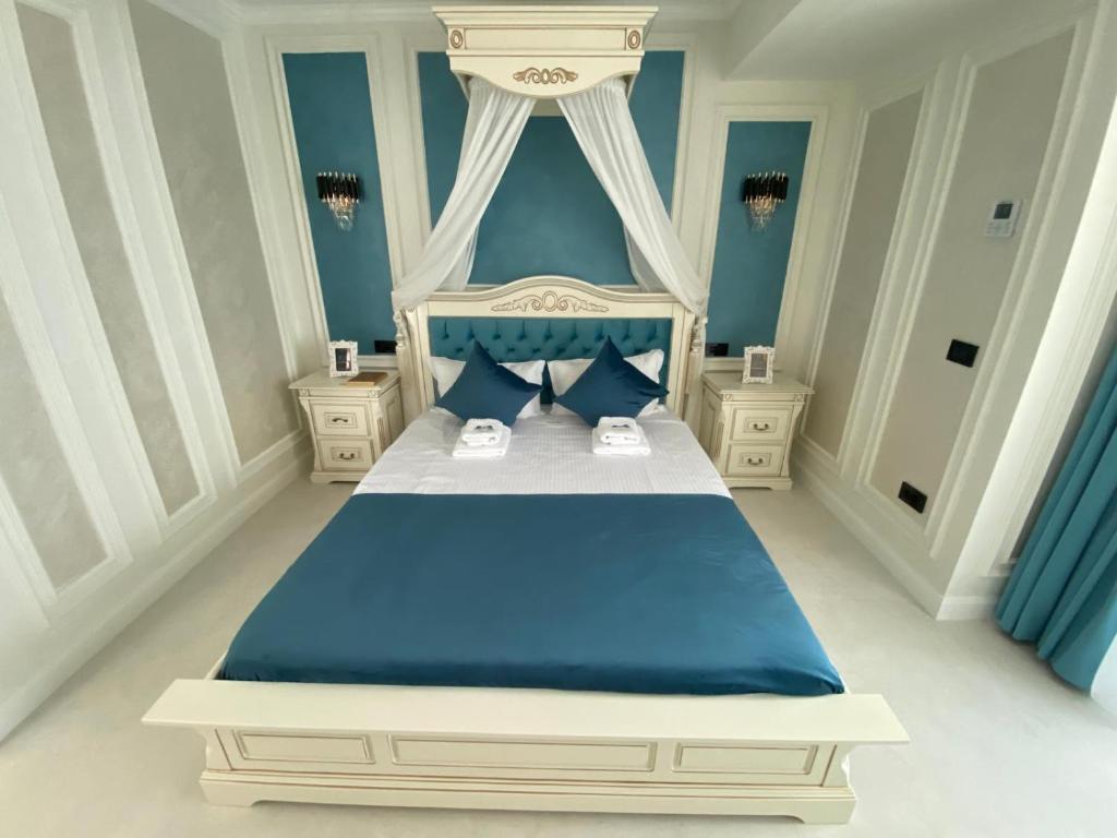 a bedroom with a blue and white bed with blue pillows at Luxury by White Titanic Breeze in Năvodari