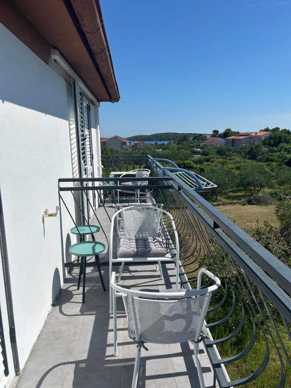a row of chairs and tables on a balcony at Apartment Kix in Rab