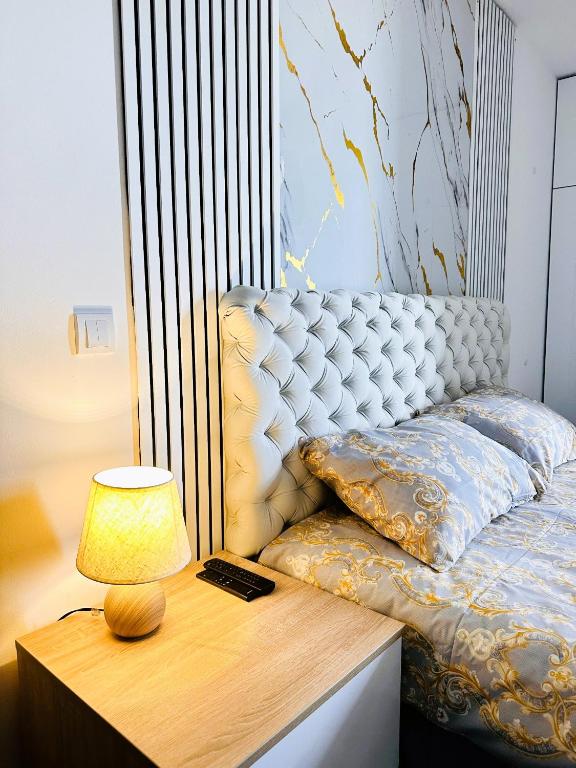 a bed with a lamp on a nightstand next to a table at Penthouse Studio Borovi in Divčibare