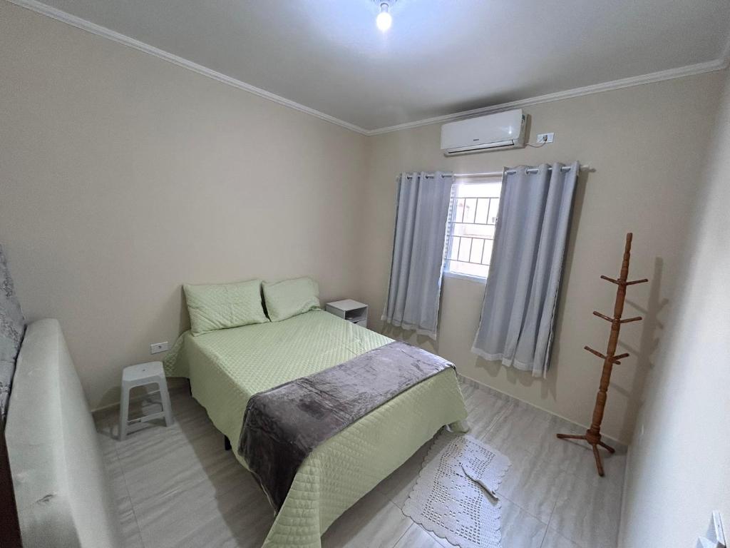 ein kleines Schlafzimmer mit einem Bett und einem Fenster in der Unterkunft Casa aconchegante a beira mar in Ilha Comprida