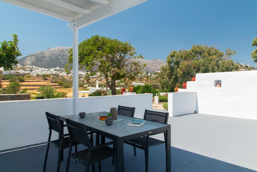 a black dining table and chairs on a balcony at Θεμωνιά house in Káto Petálion