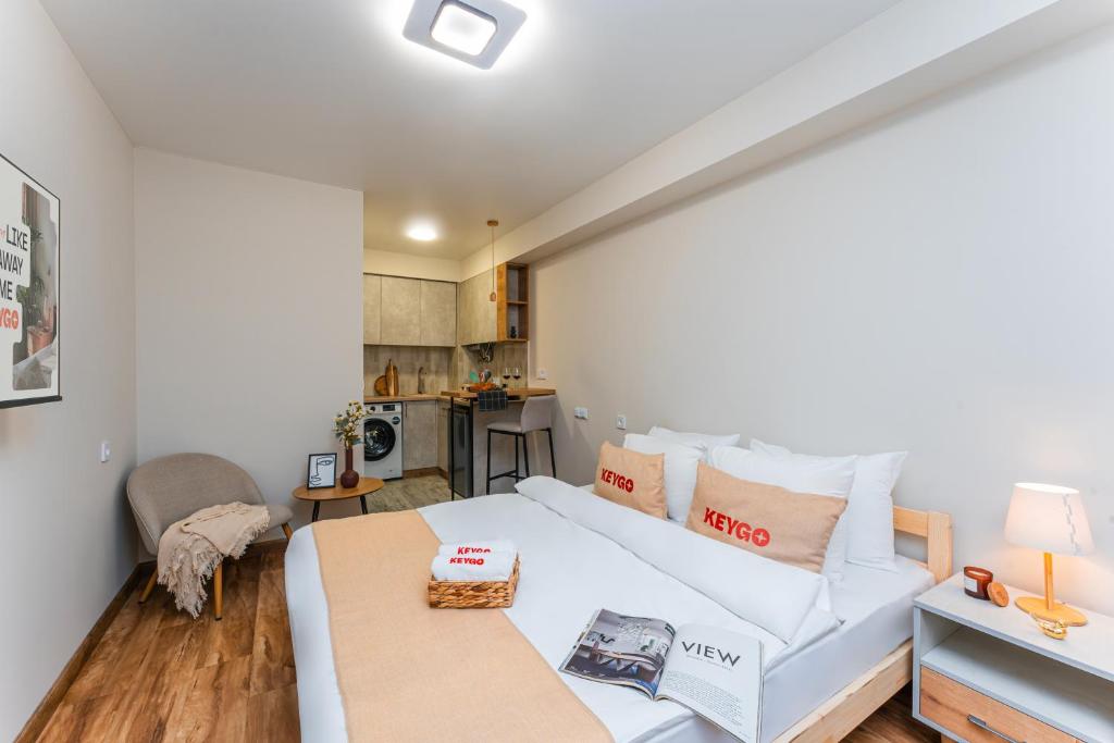 une chambre avec un lit blanc et une table dans l'établissement Studio KeyGo #0170 is the key to the center of Yerevan, à Erevan