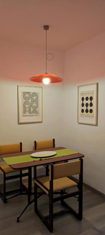 a dining room table with two chairs and a light at Casa AL CORSO Pozzuoli Centro in Pozzuoli