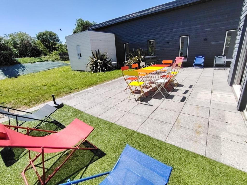 d'une terrasse avec des chaises, une table et des chaises. dans l'établissement Gîte Les Vents Salés - confort et détente dans la baie du Mt St Michel, à Roz-sur-Couesnon