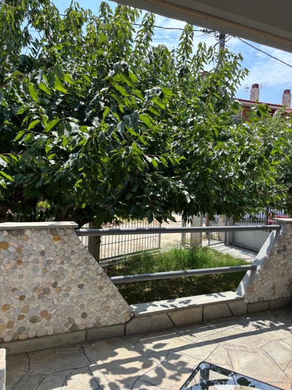 a tree in front of a building with a fence at Pebble Sea House in Orfánion