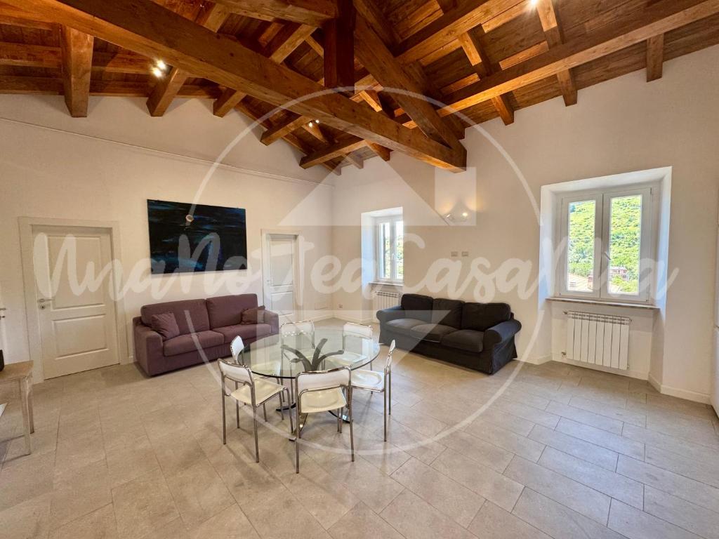 un soggiorno con un tavolo e un divano di L' Attico "UnaNotteaCasaMia" a Sacrofano