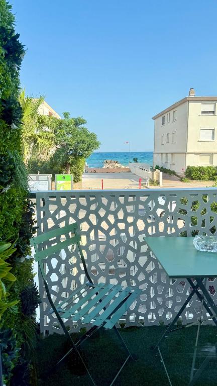 a bench with a table and a view of the beach at Entre Ciel&Mer in Palavas-les-Flots