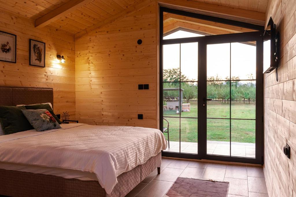 a bedroom with a bed and a large window at Nina in Golubovci