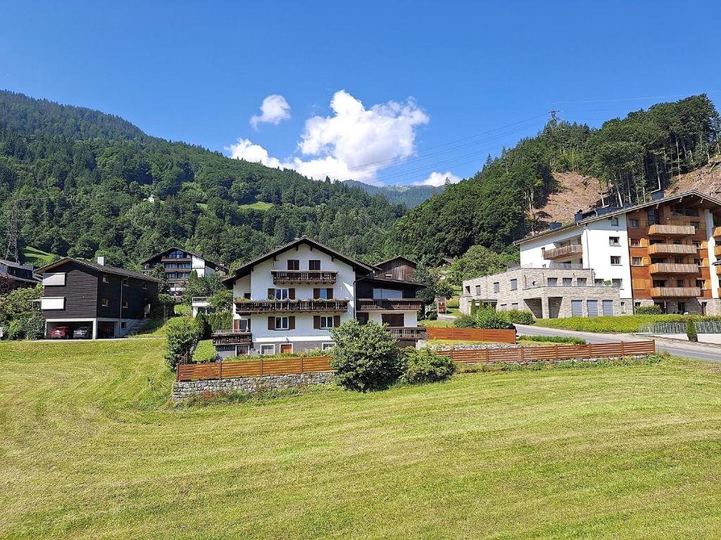 a group of houses on a hill with a grass field at Alpenfeder Hüsli in Tschagguns