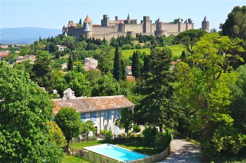 een huis met een zwembad en een kasteel bij L'Orée de la cité in Carcassonne