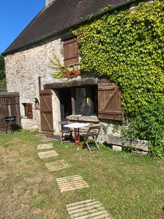 - un bâtiment en pierre avec une table de pique-nique devant dans l'établissement Le gîte de Pommette et Billy, à La Hoguette