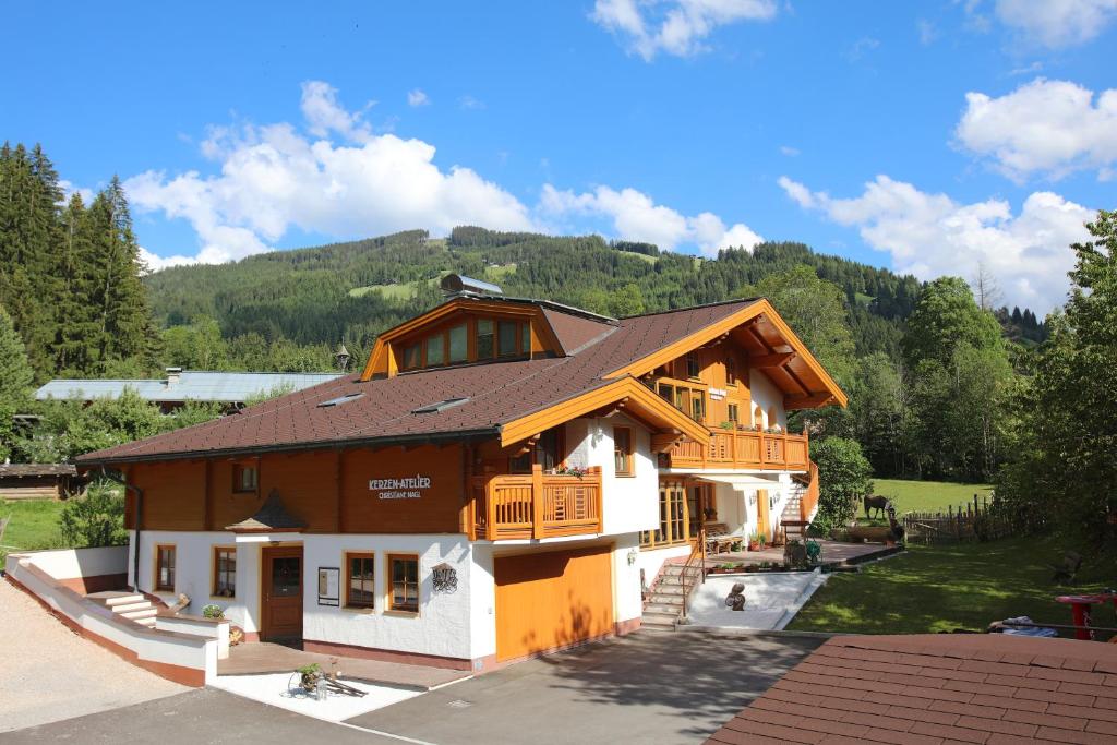 une grande maison avec une montagne en arrière-plan dans l'établissement Landhaus Nagl, à Altenmarkt im Pongau