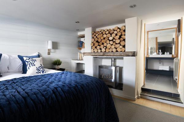 帕兹托Bryn Cottage的一间带床的卧室和一个带壁炉的壁炉