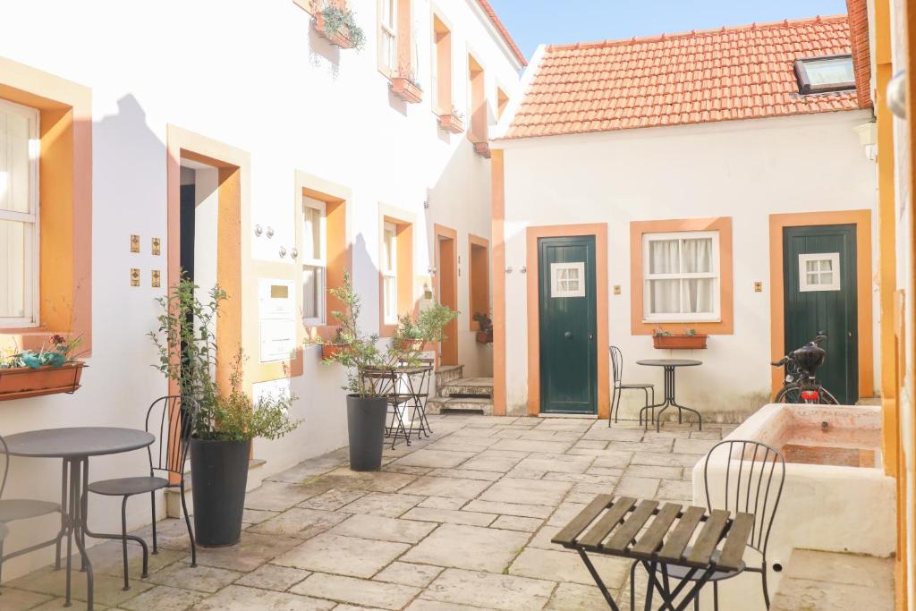 a courtyard with tables and chairs in a building at FixingInn in Santa Isabel in Lisbon