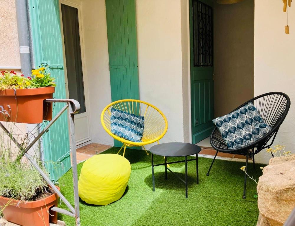 a patio with two chairs and a table and a yellow chair at Cosy studio aix en Provence à 1 minutes du cours Mirabeau in Aix-en-Provence