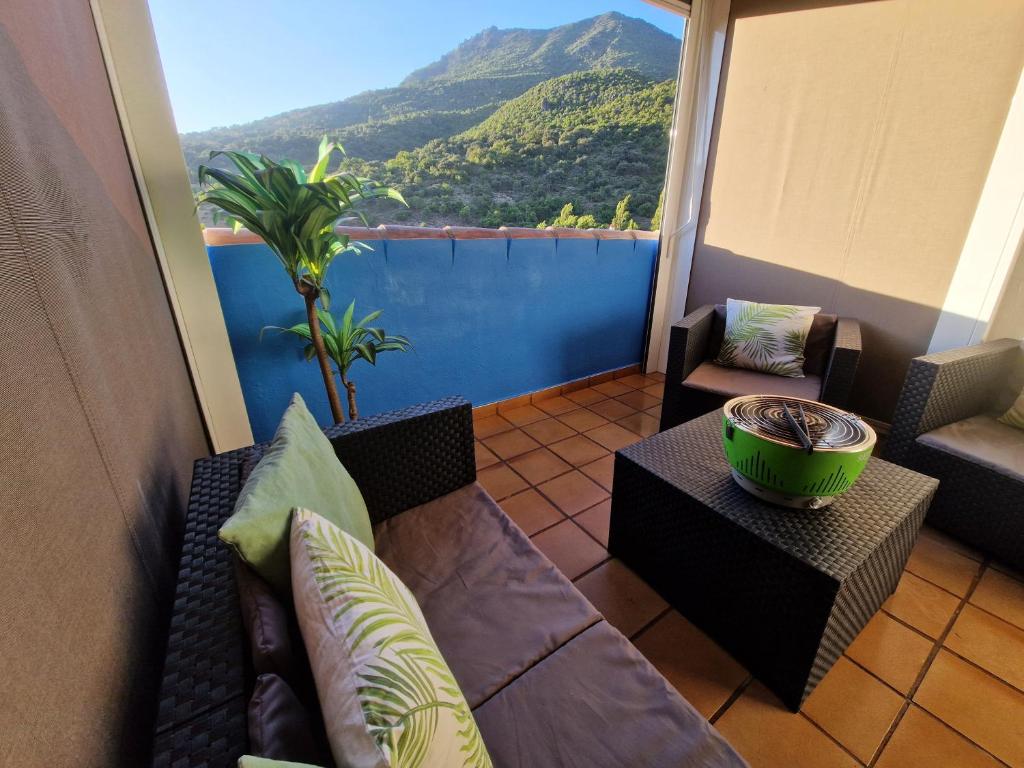 a balcony with a couch and a table and chairs at Alojamientos Sierra de Cádiz Benamahoma in Benamahoma