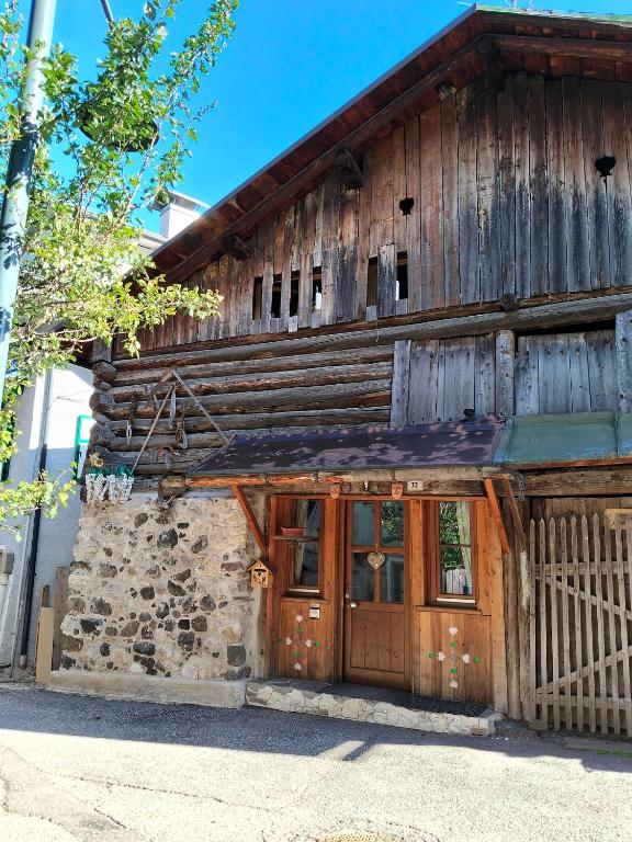 an old wooden building with a large door at Cesa Pegghy in Canazei