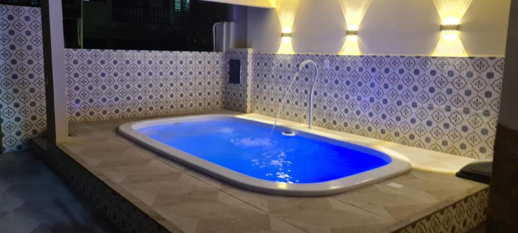 uma grande banheira azul na casa de banho em Apartamento perto de praia Dos Anjos em Arraial do Cabo